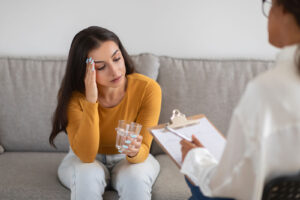 young woman in drug rehab therapy holds a glass of water