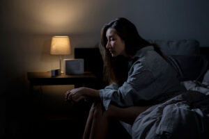 woman in bedroom feeling sad tired and worried suffering anxiety