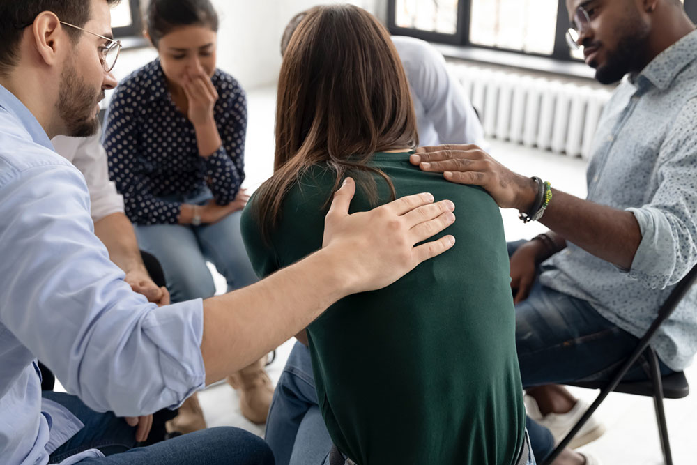 people gathered together sitting on chairs in circle during a rehab session