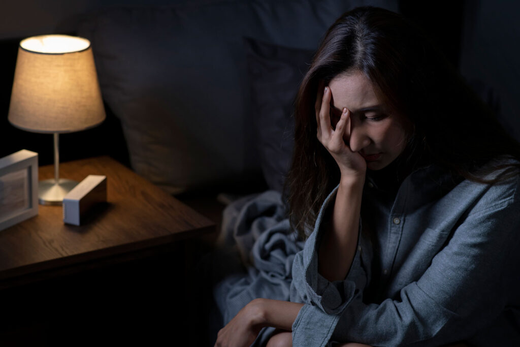 woman in bedroom feeling sad tired and worried suffering from anxiety